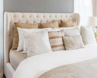 Photo of a bed with numerous different size pillows