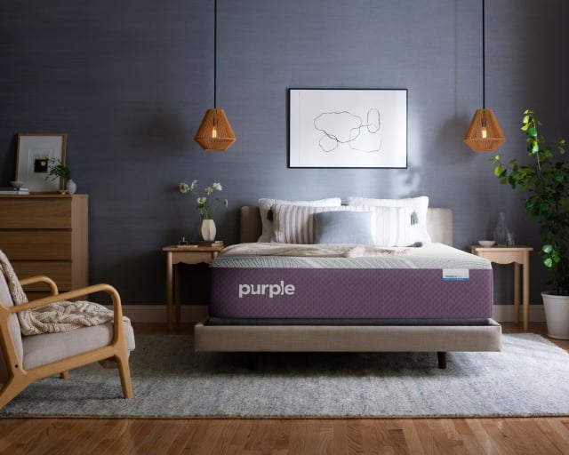 A Purple RestorePlus Hybrid Mattress in a dark bedroom.