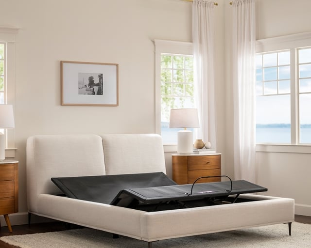 A Purple Premium Smart Base in an upholstered bed frame without a mattress.