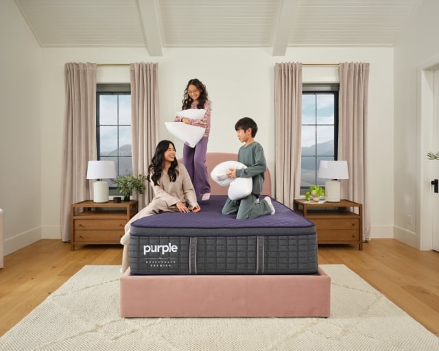 Woman and two children sitting on RejuvenatePremier mattress in bedroom