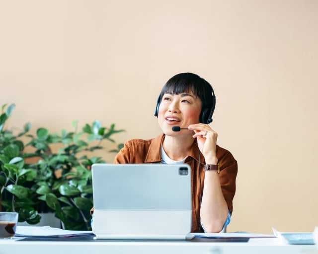 Woman talking on headset at a desk