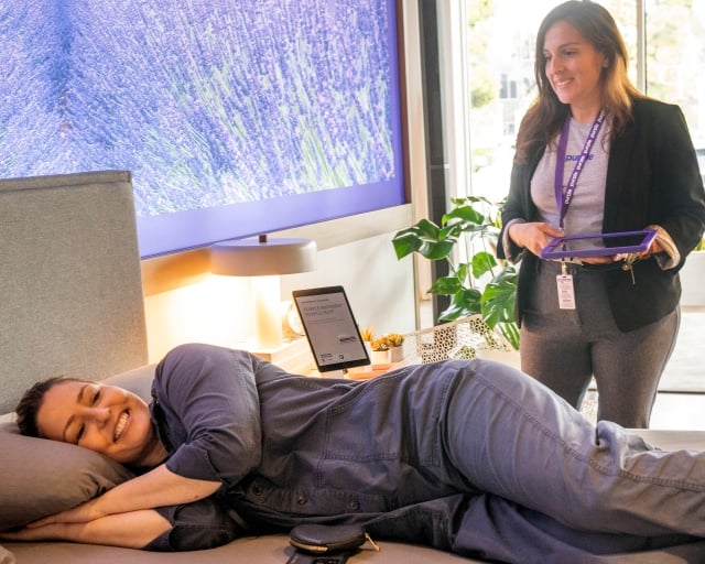 Woman trying a mattress in a Purple showroom