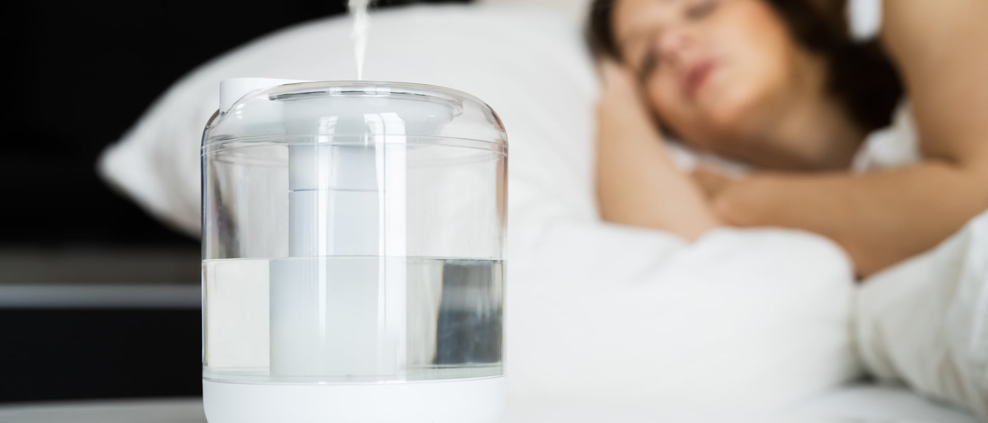 A woman sleeps with a humidifier running in the bedroom.